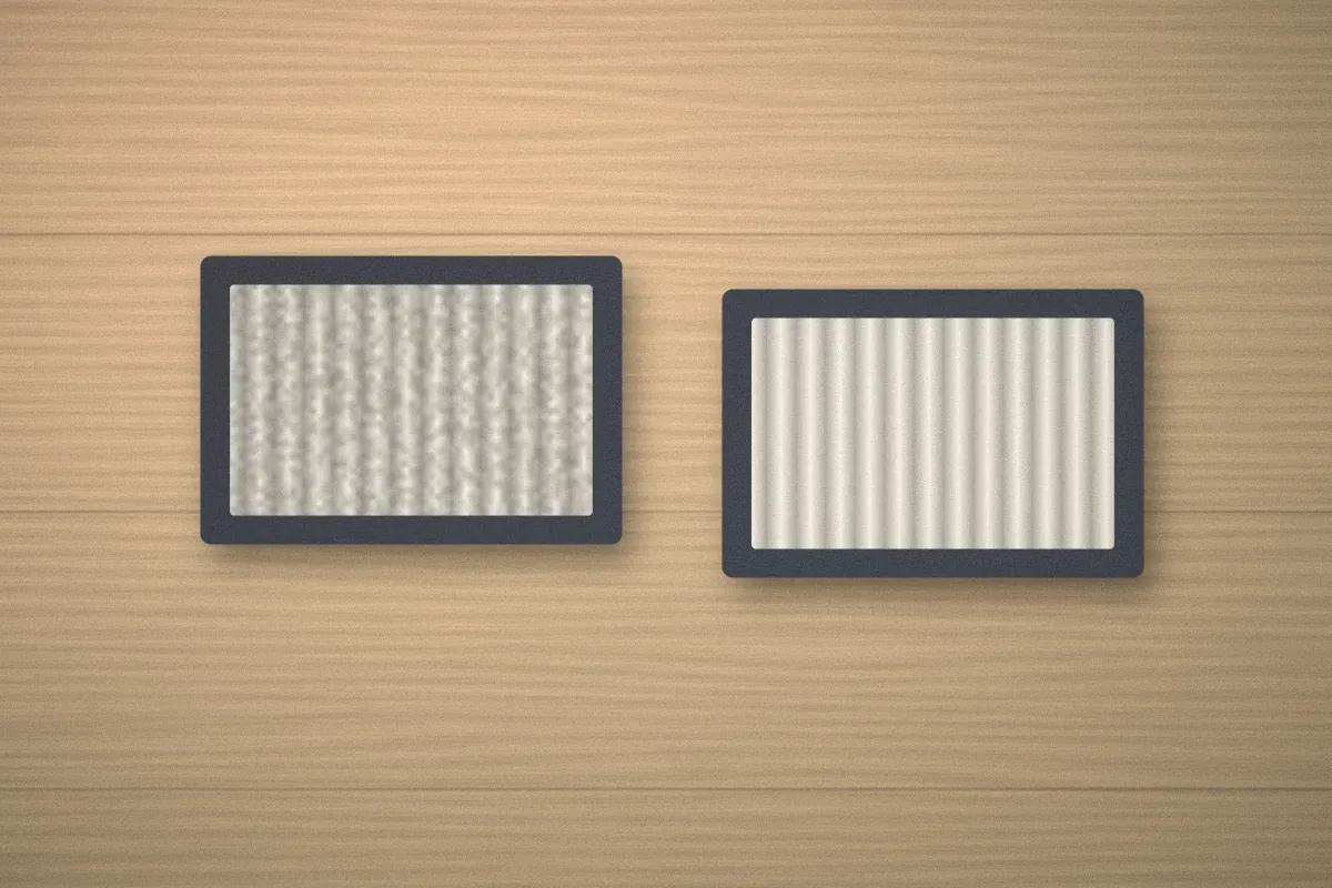 Dusty pleated filter next to a clean replacement filter on a wooden table