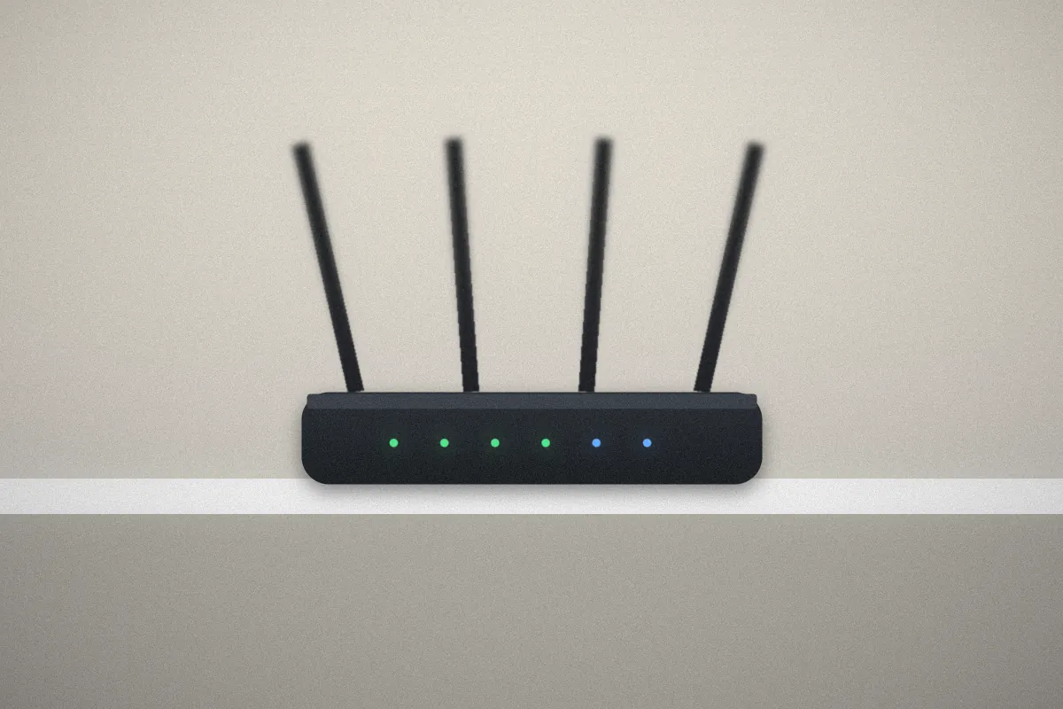 Wi-Fi router with four antennas and green status lights on a white shelf
